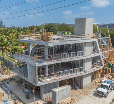 Construction of a house, featuring a concrete frame with exposed structural beams and studs