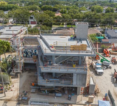A house being framed with concrete, showing visible beams and studs