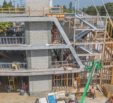 Wooden structure of a house under construction, displaying beams and studs.