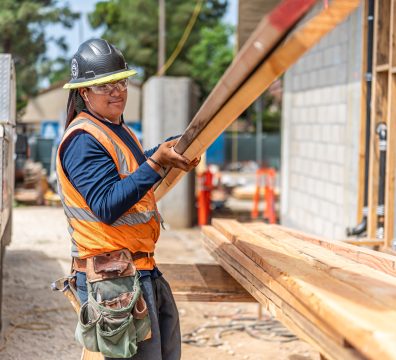 Building a house: visible wooden frame with structural beams and studs.