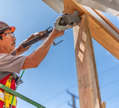 House construction with a wooden frame, highlighting exposed beams and studs