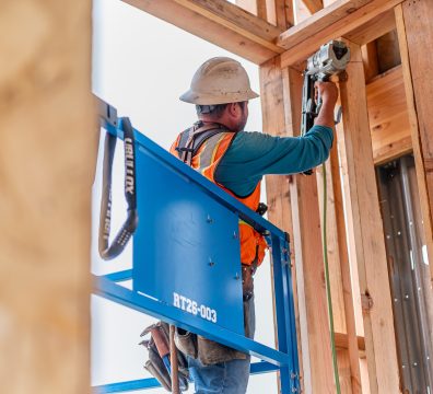 A house in the framing stage, featuring exposed wooden beams and studs.