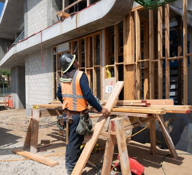 The wooden frame of a house under construction, showing exposed beams and studs."