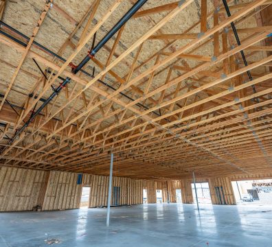 The wooden frame of a house under construction, showing structural beams and studs.