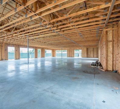 House construction phase with a wooden frame, highlighting exposed beams and studs.