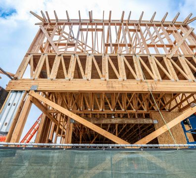 Building a house with a wooden frame, featuring exposed beams and studs.