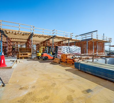 Construction of a house, featuring a wooden frame and exposed structural beams and studs.