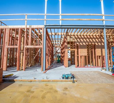 A developing house under construction, with visible wooden beams and studs