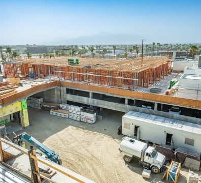The construction of a house, showcasing a wooden frame with exposed beams and studs.
