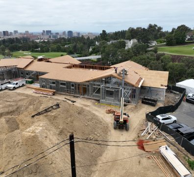 A house under construction with a wooden frame, showing beams and studs