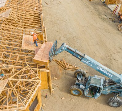 A house's wooden frame under construction, featuring structural beams and studs