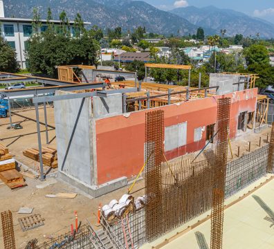 Building a house: wooden frame with beams and studs visible during construction.