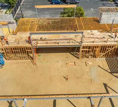 Partially built house with exposed wooden beams and studs in the frame.