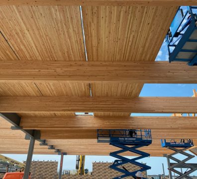 Construction of a wooden house frame, with beams and studs forming the walls and roof.