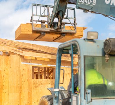 Wooden frame of a house under construction, showcasing structural beams and studs