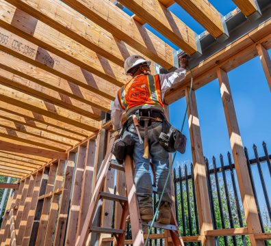 House construction in progress, featuring a wooden frame with beams and studs