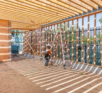 Wooden beams and studs form the frame of a house under construction.