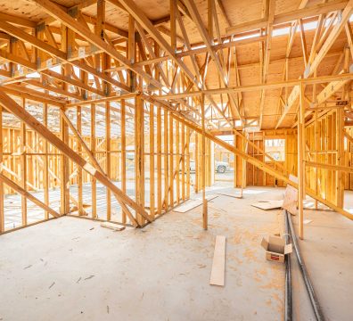 Construction phase of a house, featuring a wooden frame with visible beams and studs