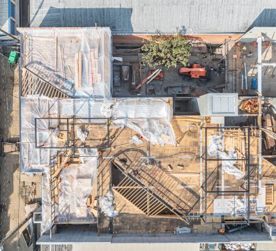 Wooden framework of a house under construction, highlighting the beams and studs.