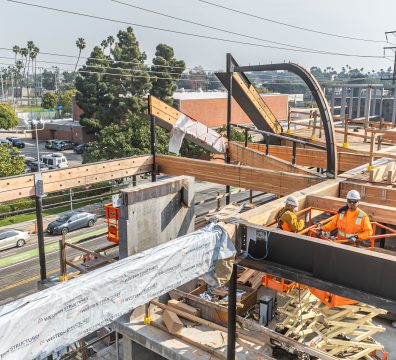 House under construction with an exposed wooden frame, including structural beams and studs.