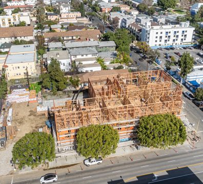 House construction phase showing the wooden frame with visible beams and studs.