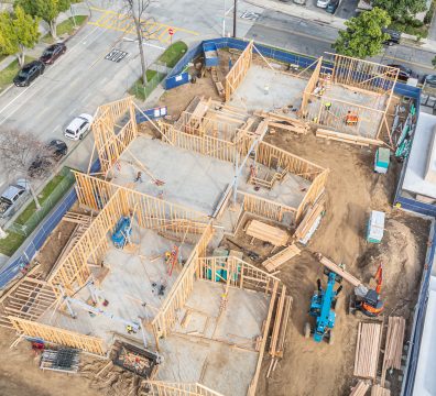 Exposed wooden beams and studs outline the construction of a house frame.