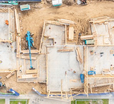 A house being built with exposed wooden beams and studs forming its frame.