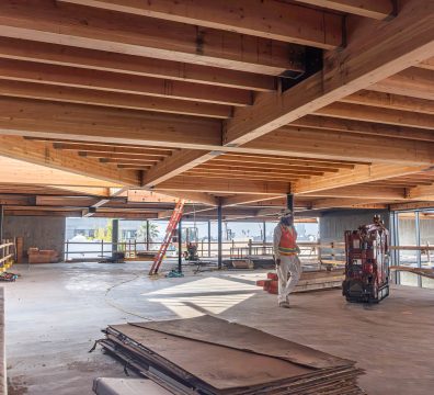 The framing of a house in progress, with wooden beams and studs creating the structure.