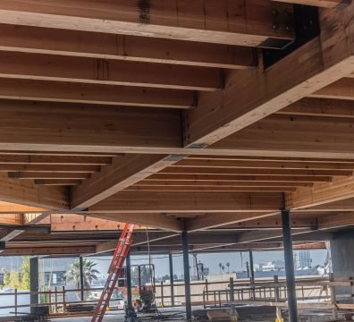 A house's structural wooden frame under construction, with exposed beams and studs.