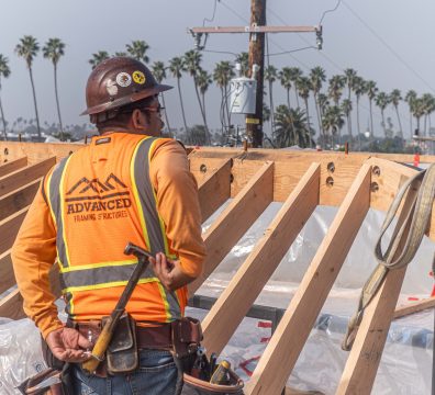 Construction site of a house, featuring a wooden frame with visible beams and studs.