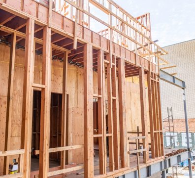 Wooden beams and studs creating the framework of a house under construction.