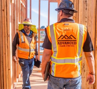 Visible wooden structure of a house under construction, with beams and studs forming the framework.