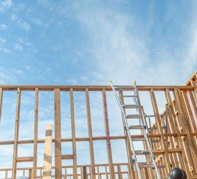 The framing of a house, made of wooden beams and studs, is under construction.