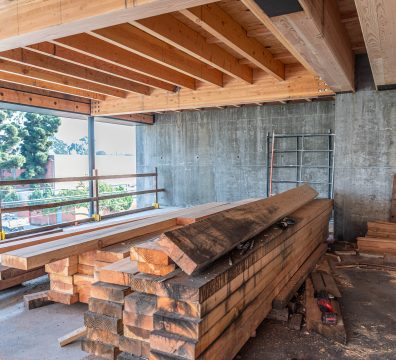 Wooden house frame under construction, showcasing the exposed beams and studs.