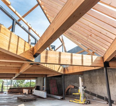 Construction of a house with exposed wooden beams and studs in the frame.