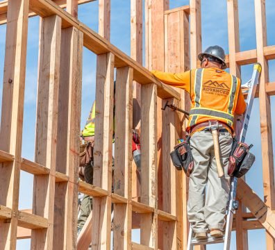 Wooden framing of a house under construction, showcasing beams and studs.