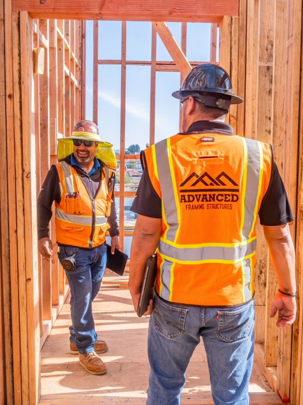 Visible wooden structure of a house under construction, with beams and studs forming the framework.